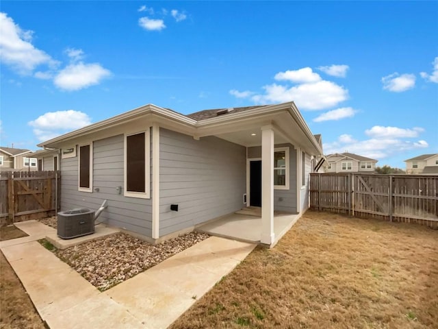 rear view of property featuring a patio area, a fenced backyard, a gate, and central AC