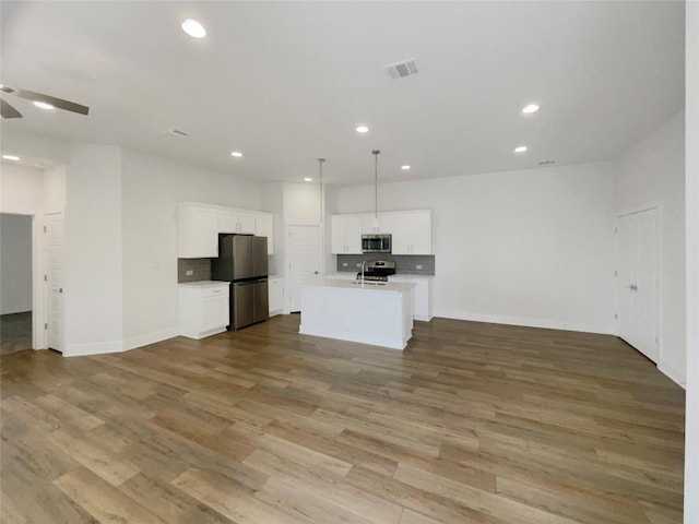 kitchen with open floor plan, stainless steel appliances, and decorative backsplash