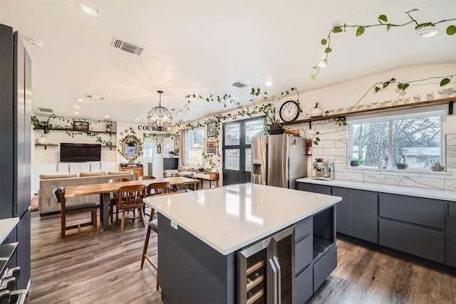 kitchen featuring dark wood-style flooring, modern cabinets, visible vents, and stainless steel fridge with ice dispenser