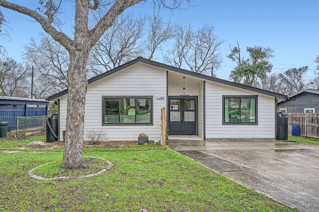 mid-century modern home with french doors, a front lawn, and fence