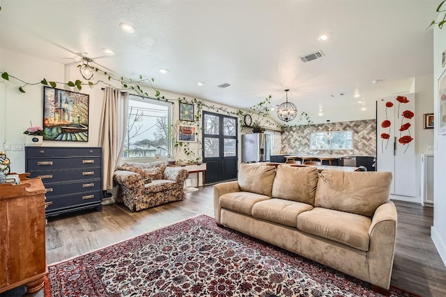 living room featuring a notable chandelier, wood finished floors, visible vents, and recessed lighting