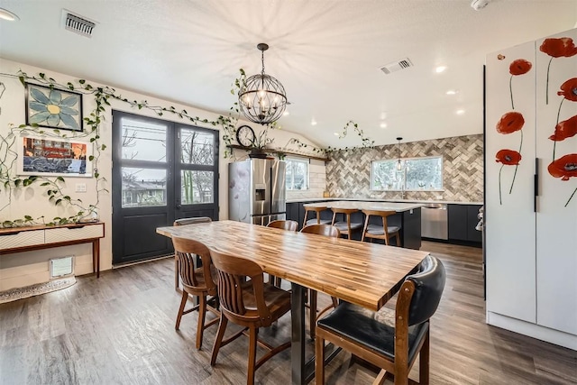 dining space featuring dark wood-style flooring, visible vents, and plenty of natural light