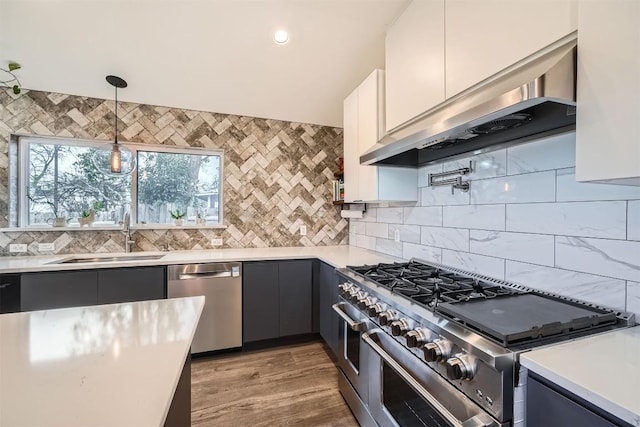 kitchen with under cabinet range hood, stainless steel appliances, a sink, and light countertops