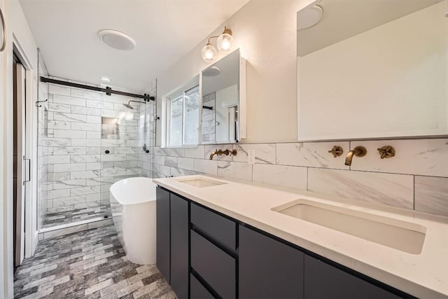 full bathroom featuring a sink, tile walls, a soaking tub, a shower stall, and double vanity