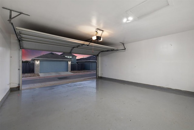 garage with a garage door opener and baseboards