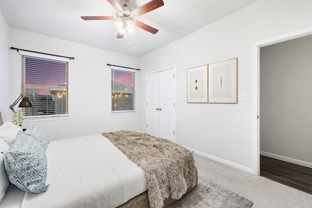 carpeted bedroom featuring electric panel, a closet, baseboards, and ceiling fan