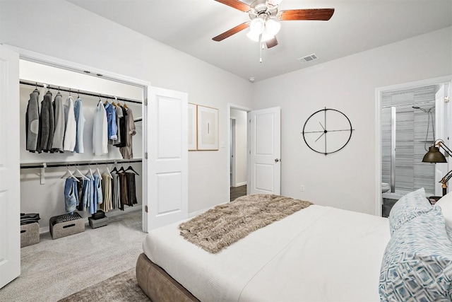 carpeted bedroom with a closet, visible vents, ensuite bath, and a ceiling fan