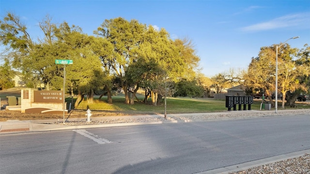 view of street featuring street lights, curbs, and sidewalks