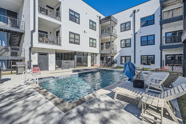 community pool with a patio and a grill