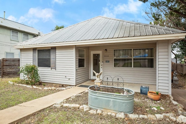 view of front of house with metal roof and fence