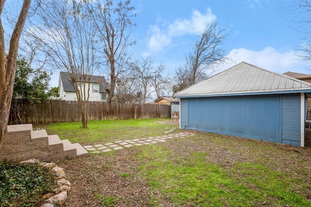 view of yard with fence and an outbuilding