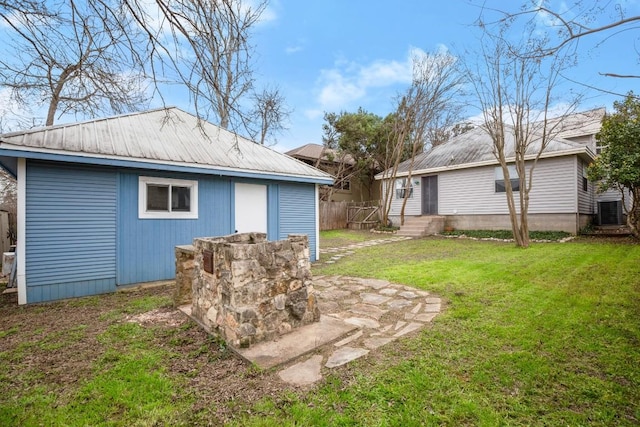 view of yard featuring entry steps, central AC, fence, and an outdoor structure