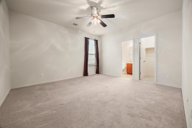 unfurnished room featuring baseboards, a ceiling fan, visible vents, and light colored carpet