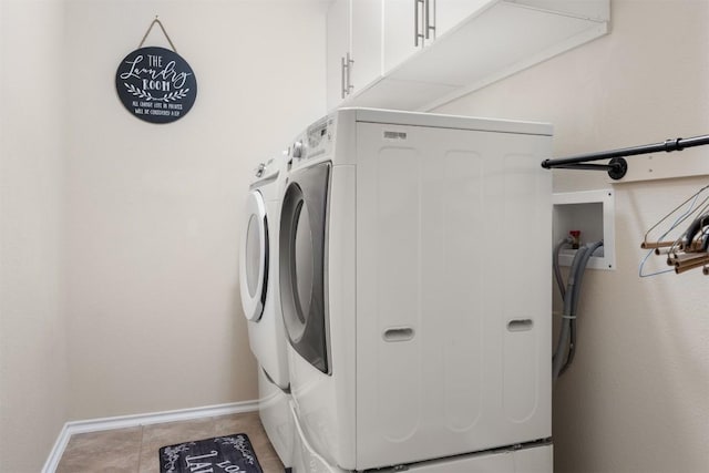 clothes washing area featuring cabinet space, baseboards, and separate washer and dryer