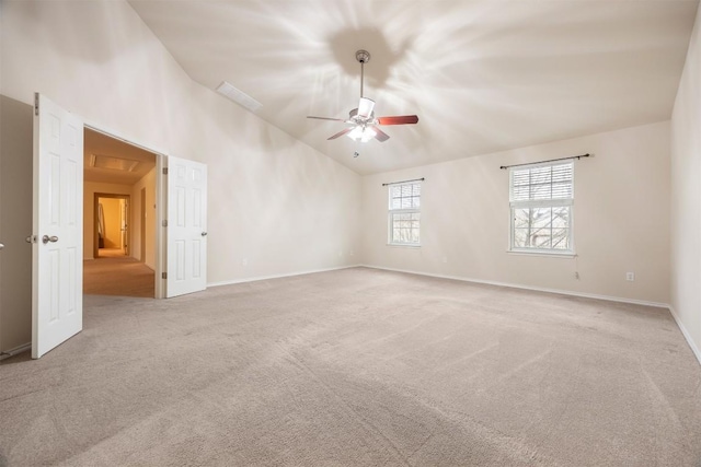 carpeted empty room featuring lofted ceiling, ceiling fan, and baseboards