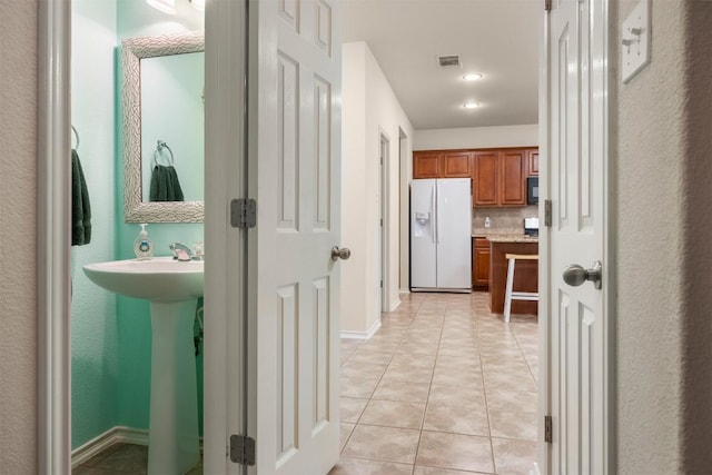 corridor featuring light tile patterned flooring and visible vents