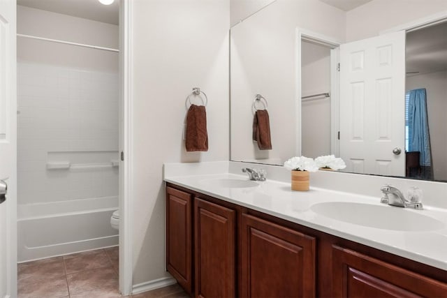 bathroom with tile patterned flooring, a sink, toilet, and double vanity