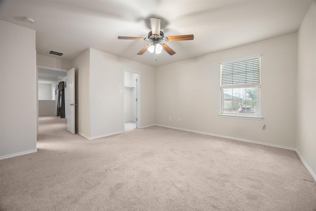 empty room with light carpet, visible vents, and baseboards