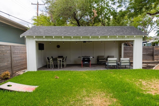 rear view of property with a shingled roof, a patio area, a lawn, and fence