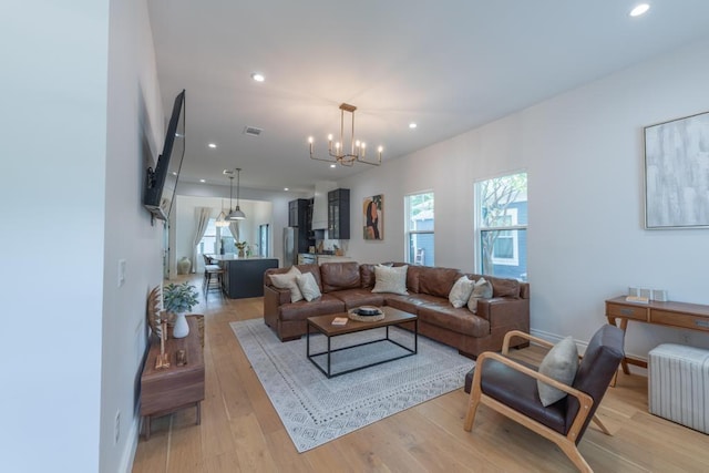 living area with recessed lighting, visible vents, light wood-style flooring, and radiator heating unit