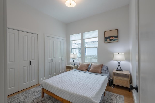 bedroom featuring multiple closets and light wood-type flooring