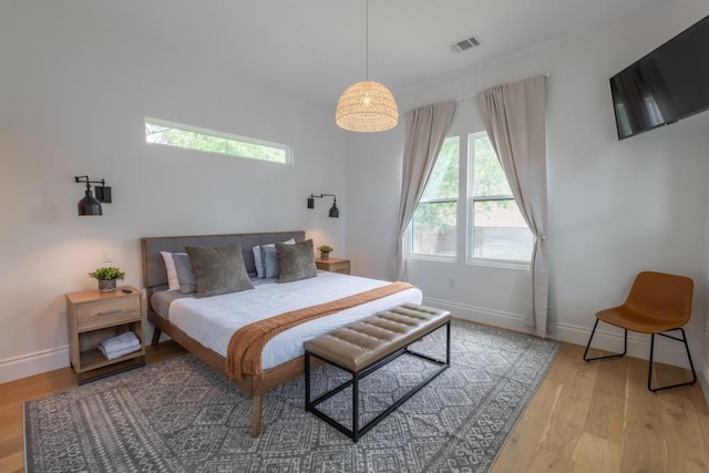 bedroom featuring light wood-type flooring, visible vents, and baseboards