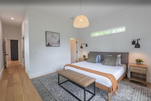 bedroom with light wood-type flooring, baseboards, and recessed lighting