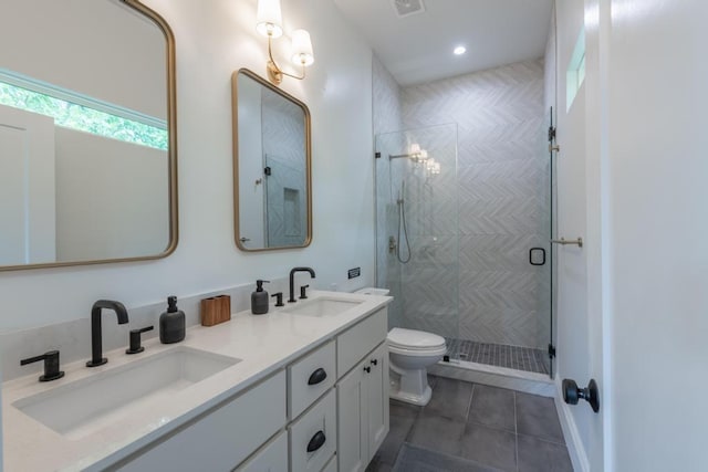 bathroom featuring a sink, a shower stall, toilet, and double vanity