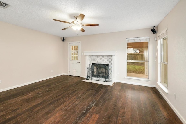 unfurnished living room featuring hardwood / wood-style flooring, plenty of natural light, visible vents, and a textured ceiling