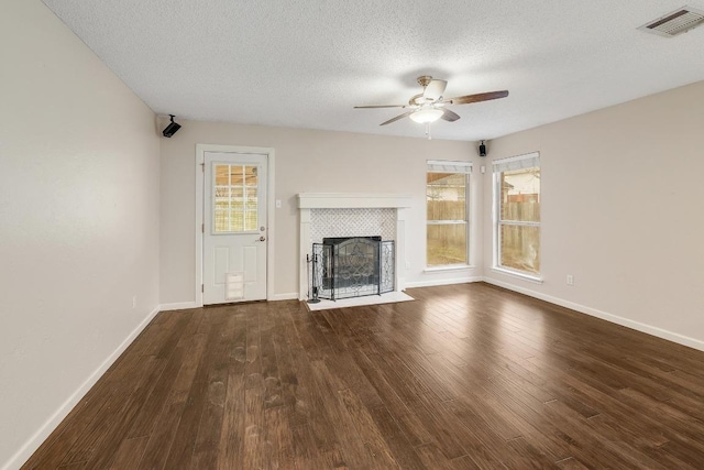 unfurnished living room featuring visible vents, wood finished floors, and a wealth of natural light