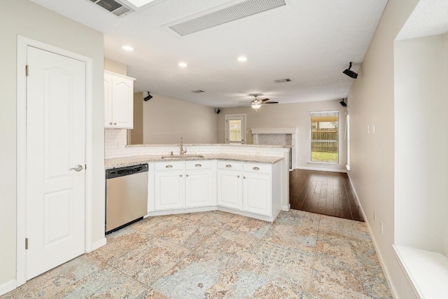 kitchen featuring a peninsula, stainless steel dishwasher, a sink, and visible vents