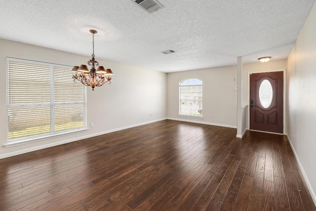 foyer with visible vents, dark wood finished floors, baseboards, and an inviting chandelier