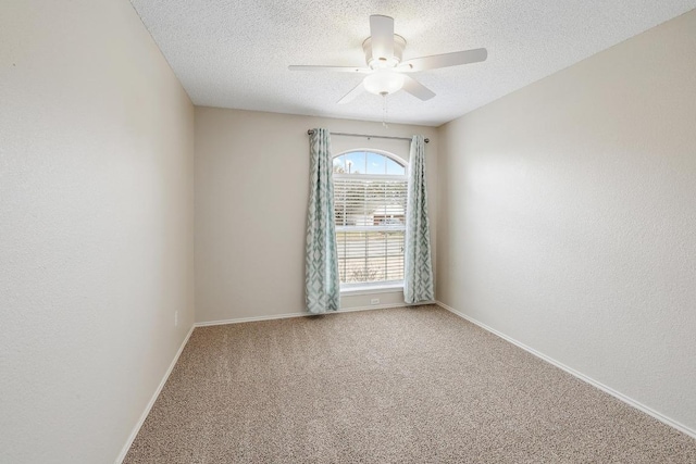 carpeted spare room with a textured ceiling, ceiling fan, and baseboards