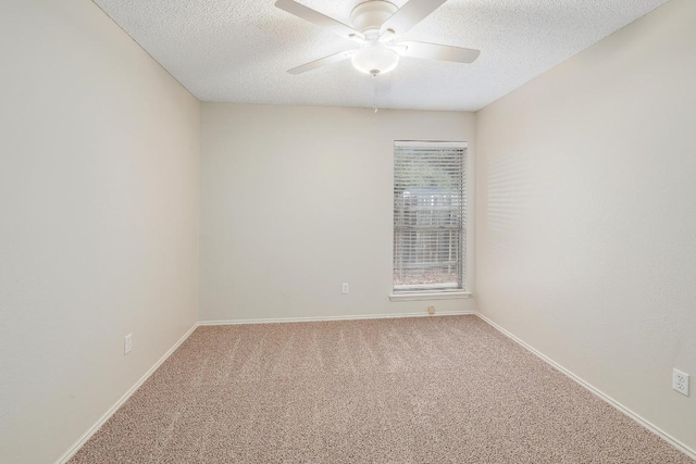 carpeted empty room featuring a ceiling fan, a textured ceiling, and baseboards