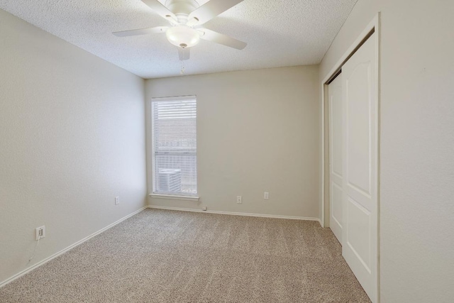 unfurnished bedroom with carpet floors, a closet, baseboards, and a textured ceiling