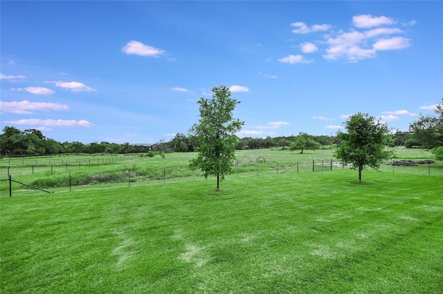 view of yard with a rural view and fence