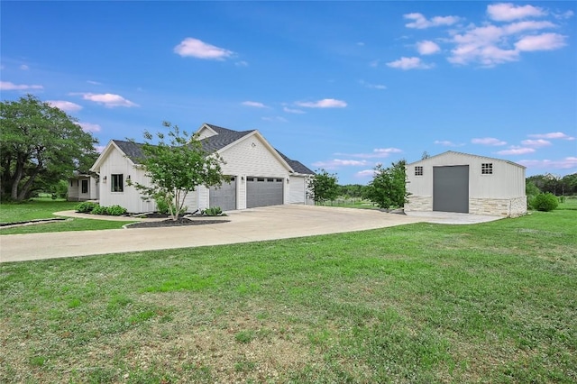 exterior space featuring driveway, stone siding, a front lawn, and an outdoor structure