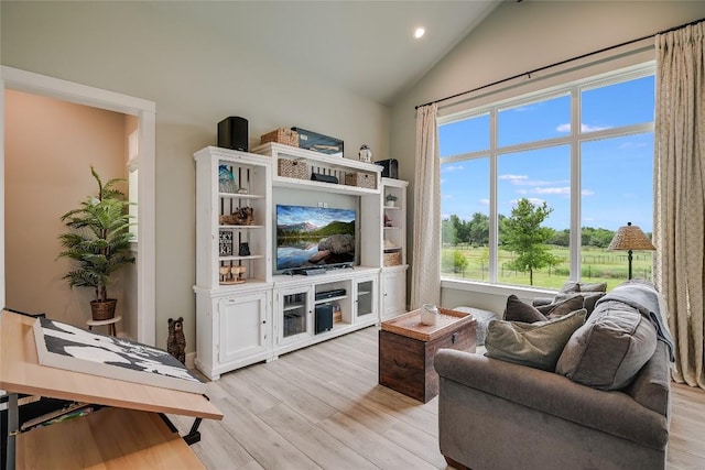 living area with light wood-style flooring and vaulted ceiling