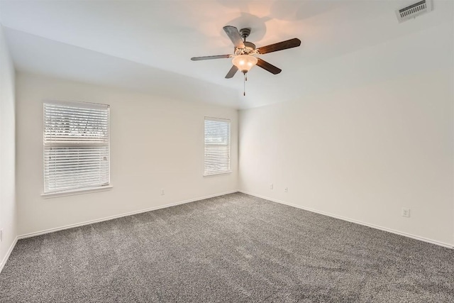 spare room with carpet, visible vents, ceiling fan, and baseboards