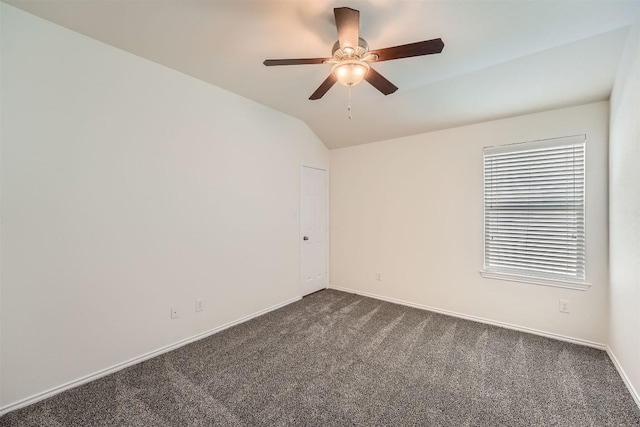 empty room featuring lofted ceiling, baseboards, dark colored carpet, and a ceiling fan