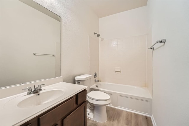 full bathroom featuring toilet, shower / bath combination, wood finished floors, and vanity