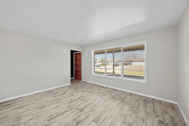 spare room featuring light wood-style flooring and baseboards