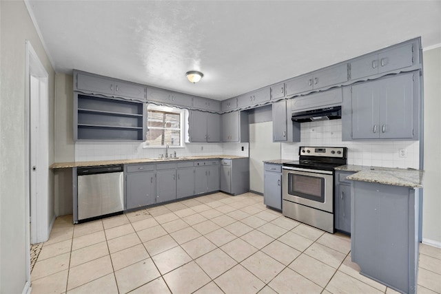 kitchen featuring appliances with stainless steel finishes, a sink, under cabinet range hood, and gray cabinetry