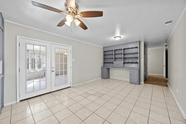 empty room featuring baseboards, visible vents, crown molding, french doors, and built in desk