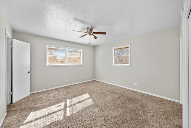 unfurnished bedroom featuring carpet, multiple windows, and baseboards