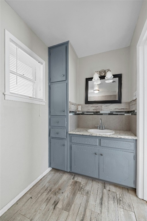 bathroom featuring tile walls, vanity, and wood finished floors