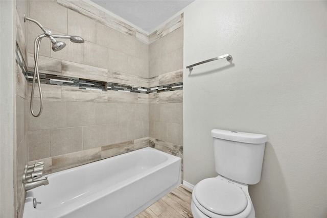 bathroom featuring shower / bathing tub combination, wood finished floors, toilet, and baseboards