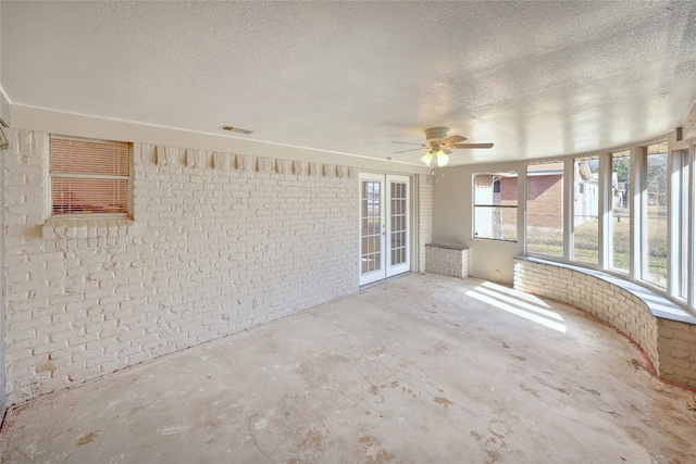 unfurnished sunroom with visible vents and a ceiling fan