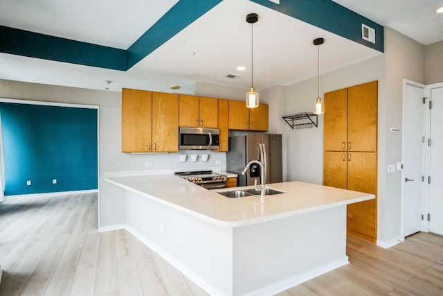 kitchen with visible vents, brown cabinetry, appliances with stainless steel finishes, light wood-type flooring, and a sink