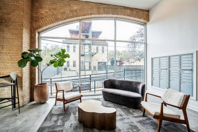 507 Sabine St Unit 1010, Austin, TX 78701 - living area featuring mail area, brick wall, and a towering ceiling